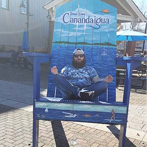 A photographic image of Paul Wise seated in a uniquely over-sized 
beach chair. This Photographic Image of Paul Wise seated in a uniquely over-sized beach chair was taken in The 
U.S.-City-State of Canandaigua, N.Y., U.S. On the West-Avenue of The City-St.-of-Main OF The U.S.-City-State of 
Canandaigua, N.Y., U.S.